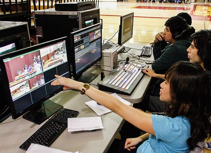 Benjamin Simpson / Courier Amy Khuong (front to back), Brandon Olguin, Jerome Chan, DeMario Ray work on live video at the men's and women's basketball game at the Hutto-Patterson Gym, Feb 15, 2013. The Television Field Production class is hoping to produce live games to view on the internet in the future.