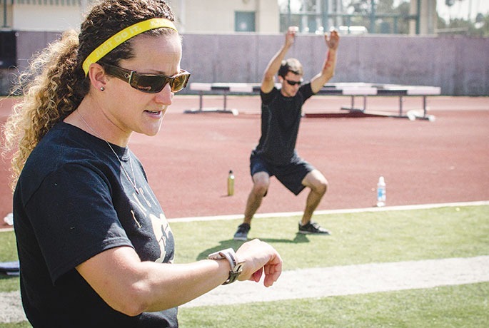 Matthew Chan / Courier When she's not coaching, the new head coach of PCC"s softball team, Monica Tantlinger also teaches a cardiovascular conditioning class in Robinson Stadium, Sept. 19, 2013. Tantlinger keeps track of time as her students perform their conditioning drills.