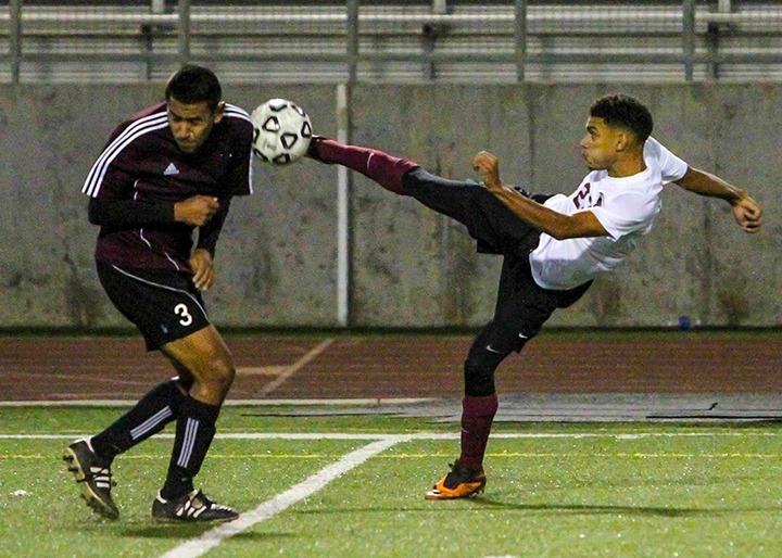 Zach Larson attempts to center the ball against Bryan Rodriguez during the Lancers 5-2 win over ECC Compton Center in their final regular season game at home in Robinson Stadium on Friday Nov 15, 2013. The Lancers finished 7th in Southern California and will play Oxnard College (15-5-1) in the first round of the playoffs on Saturday Nov 23 at Azusa Pacific University at 2pm. (Courier/Benjamin Simpson)